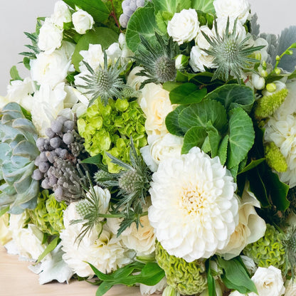 A soft color scheme is excellent for a variety of condolence occasions. The kind of flowers used will vary with the seasons. Allow our designers to put up a unique vase arrangement for you using the freshest blooms available.  NOTE: Blooms are delivered in a vase.